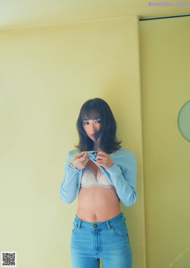 A woman standing in front of a mirror in a room.