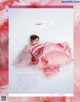 A woman in a pink dress laying on a bed of pink tulle.